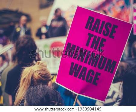 A Raise The Minimum Wage Sign At Worker's Rights Protest Or Rally Royalty-Free Stock Photo #1930504145