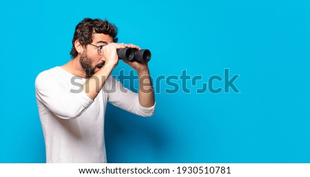 young crazy bearded man with binoculars Royalty-Free Stock Photo #1930510781