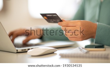 Close up of woman hand working with laptop and credit card at home , paying,payment,buying and online shopping concept.