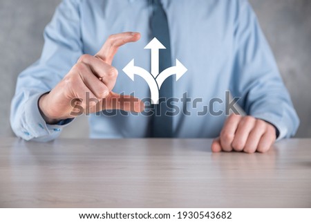 Businessman in a suit holds a sign showing three directions. in doubt, having to choose between three different choices indicated by arrows pointing in opposite direction concept. three ways to choose