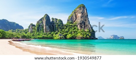 Panorama of beautiful sand Railay beach and thai traditional wooden longtail boat in Krabi province. Ao Nang, Thailand. Royalty-Free Stock Photo #1930549877