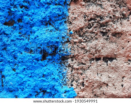 Blue and pink paint on a rough cement wall.