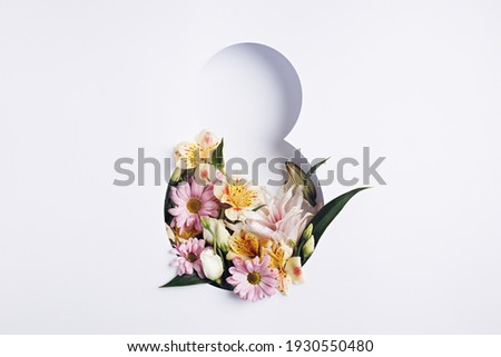 Number 8 with fresh spring flowers with green leaves on bright white background. Minimal Women's day, March 8th or birthday concept. Flat lay, top view. Royalty-Free Stock Photo #1930550480