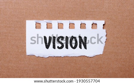 On a brown background, white paper with the inscription VISION