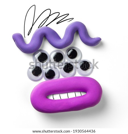 monster face with many eyes. Plasticine parts of the face with drawn elements 