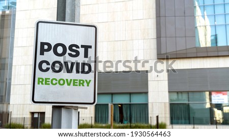 Post covid recover sign in a downtown city setting
