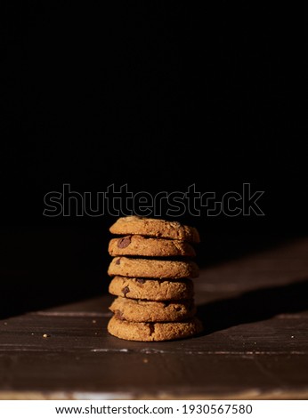 Stack of cookies with dark background. Chocolate chip. Black background. Wooden table. Dessert. Food Photography. High Resolution. Snack food. Bakery. Holidays. 