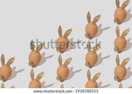 Easter decoration pattern with gold ears bunny or rabbit made of natural eggs on white background. Easter minimal composition. Flat lay.