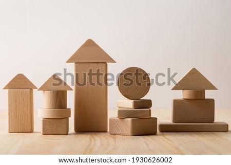 housing construction concept and housing investment with wooden toy houses on a light background with copy space.