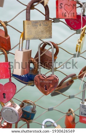 Love padlocks with heart shape.  Concept of love. Metallic  love padlock on a bridge full of padlocks.