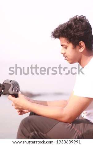 young indian boy playing with skates holding in hands