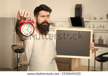 Restaurant information. Time management is key ingredient in eating right. Man with blackboard copy space. Chef kitchen with clock. Time to eat. Dinner time. Hipster cook. Interval fasting diet.