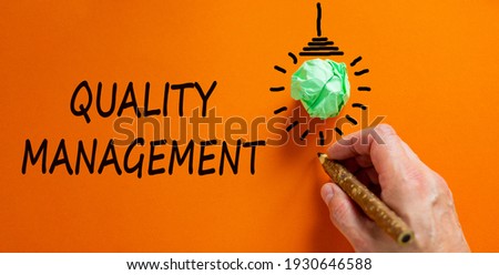 Quality management symbol. Businessman writing words 'Quality management', isolated on orange background. Light bulb icon. Business, quality management concept. Copy space.