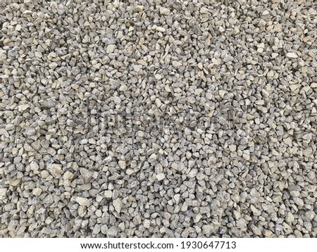 Gray small rocks ground texture. black small road stone background. gravel pebbles stone seamless texture, marble. dark background of crushed granite gravel, close up. grey clumping clay Royalty-Free Stock Photo #1930647713