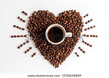 Show your love with a coffee. A cup inside a beating heart made of coffee beans on a white background. Royalty-Free Stock Photo #1930648889