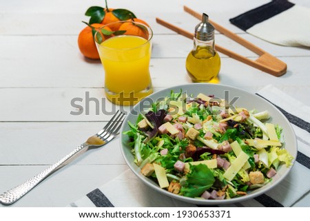 Mediterranean salad with olive oil and orange juice on white wooden table