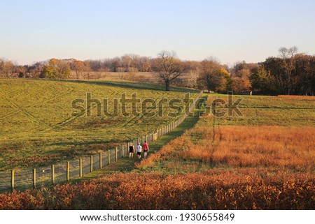 People taking a leisure walk on the trail at Stroud Preserve before sunset in late fall, West Chester, Pennsylvania, USA Royalty-Free Stock Photo #1930655849