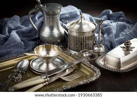 Silver dishes on old background Royalty-Free Stock Photo #1930663385