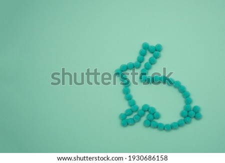 Rabbit contours made of green round cotton wool. Bunny on mint background.