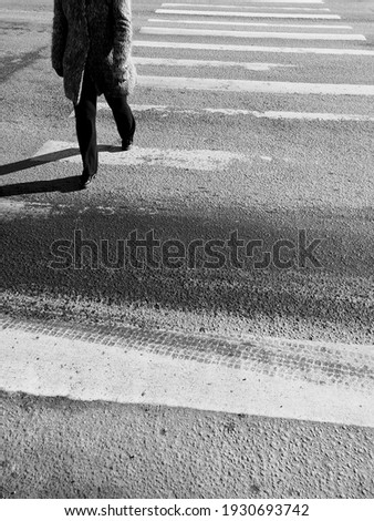 Asphalt texture background with feet citizen crossing road on pedestrian zebra on sunny day 