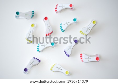 Clothespin or clothes peg of various colours shaped as feet or footsteps. Concept of: world nations, travel after pandemia, joyfull clothes drying.