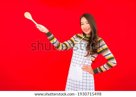 Portrait beautiful young asian woman with pan ready to cook on red background