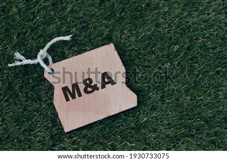 Wooden tag written with text M and A stands for Mergers and Acquisitions.