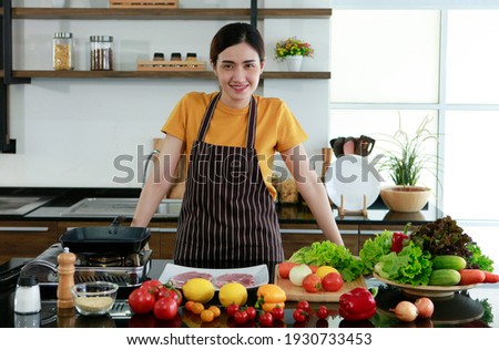 Young Asian beautiful pretty cute wife chef woman standing in kitchen in front vegetables show family before cooking food. cook food steak vegetables healthy work , stay at home for safety concept