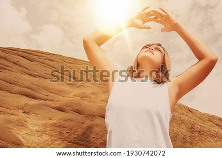 Picture of an Asian woman looking up And stand against the hot sun With a mood. of frustration Focus on face