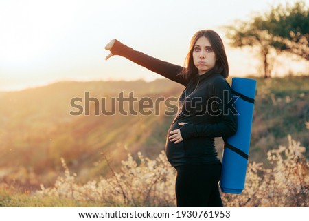 Pregnant with Yoga Mat Holding Thumbs Down, Mother to be feeling negative and pessimistic 

 Royalty-Free Stock Photo #1930761953
