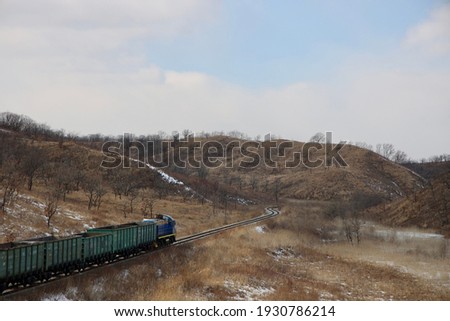 A train on a steel track across mountains