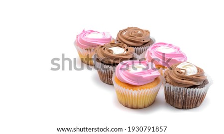 Chocolate and vanilla cupcakes with whipped raspberry and coffee cream, on a white isolated background. Selective focus.Horizontal view