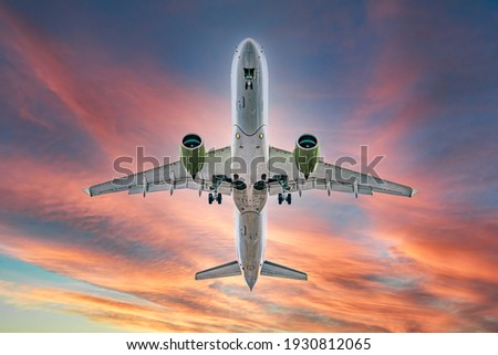 Commercial airplane jetliner flying above dramatic clouds in beautiful sunset light. flight travel transport airline background concept. Airplane in the sunset sky Royalty-Free Stock Photo #1930812065