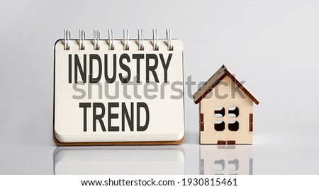 Industry Trends words written in an office notebook with wooden house. Financial Business