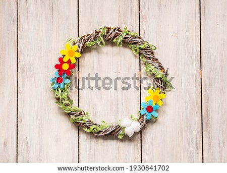 Step by step production of Easter wreath on white wooden background. Step four, ready-made Easter wreath. Children creativity, crafts, DIY