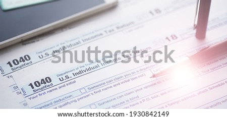 Annual tax reporting. Tax form on the table. Financial statements signature.