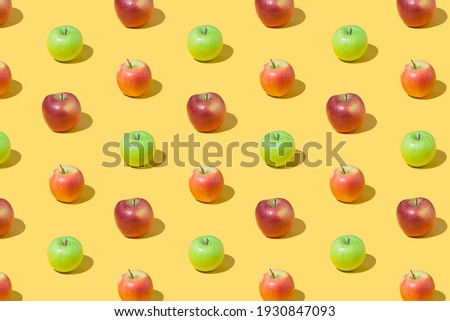 Creative pattern made of red and green apple fruit on yellow background. Minimal colorful concept.