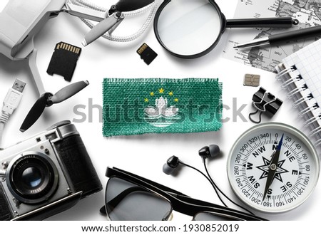 Flag of Macao and travel accessories on a white background.