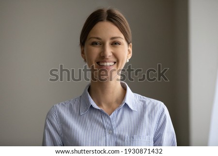Headshot portrait of smiling young Caucasian woman feel excited overjoyed at workplace in office. Profile picture of happy millennial confident successful businesswoman pose. Leadership concept.