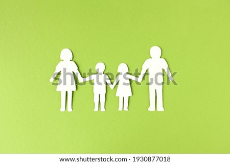 Paper chain family cut out from white paper on light green background