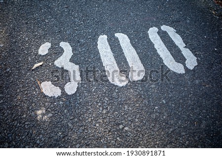 The letter 300 drawn on the asphalt