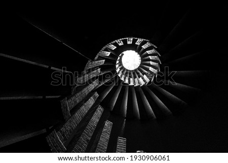 Spiral staircase with steps, upward view of a skylight, in monochrome Royalty-Free Stock Photo #1930906061