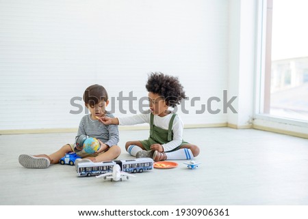 Black children and white children play with toys and have fun. Concept of apartheid And racism
