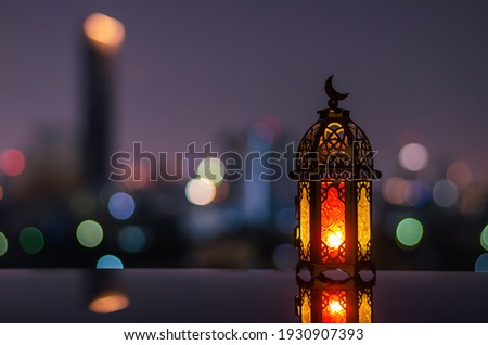 Lantern with dusk sky and city bokeh light background for the Muslim feast of the holy month of Ramadan Kareem. Royalty-Free Stock Photo #1930907393