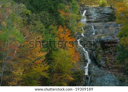The very scenic and beautiful Silver Cascades waterfall in the White Mountains of New Hampshire. Beautiful and vibrant fall colors enhance the beauty of this scene.