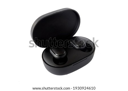 Wireless headphones isolated on white background. Close-up. Headset in charging case