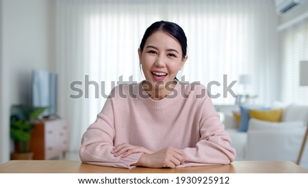 Portrait confident asia creative female vlogger make live talk video conference call, chat online on computer and sitting on table at home, Webcam view, video chat camera and Self isolation concept. Royalty-Free Stock Photo #1930925912