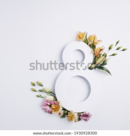 Number 8 with fresh spring flowers with green leaves on bright white background. Minimal Women's day, March 8th or birthday concept. Flat lay, top view. Royalty-Free Stock Photo #1930928300