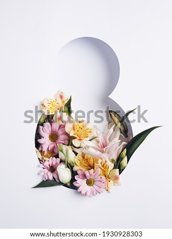 Number 8 with fresh spring flowers with green leaves on bright white background. Minimal Women's day, March 8th or birthday concept. Flat lay, top view. Royalty-Free Stock Photo #1930928303