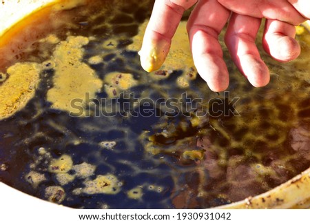 when melting wax from beehives, there is a steam flux. The dissolved visa flows into the bucket. it must not be touched it is hot. liquid yellow wax sticks to the fingers. skin burns